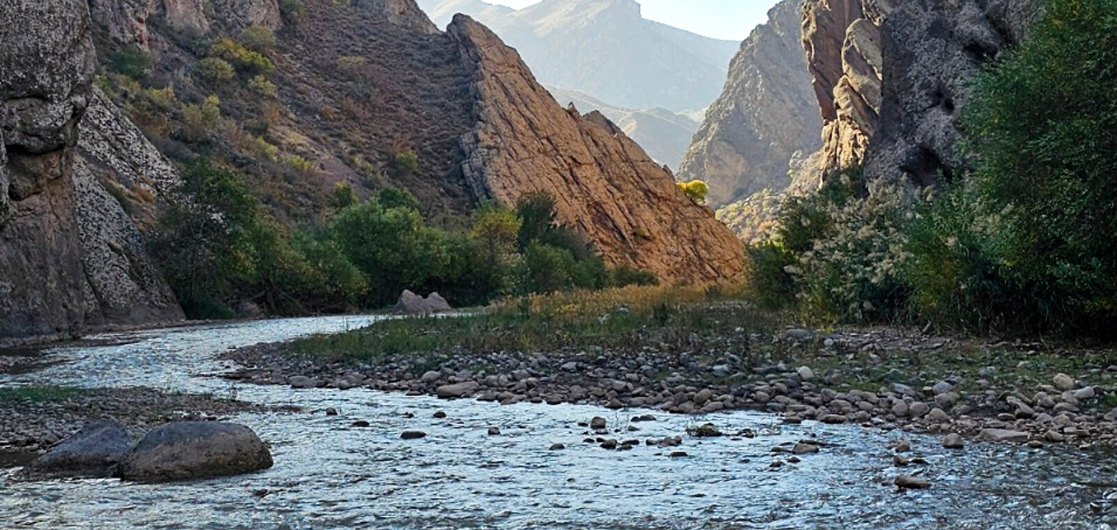 A river running through a rugged canyon between mountains