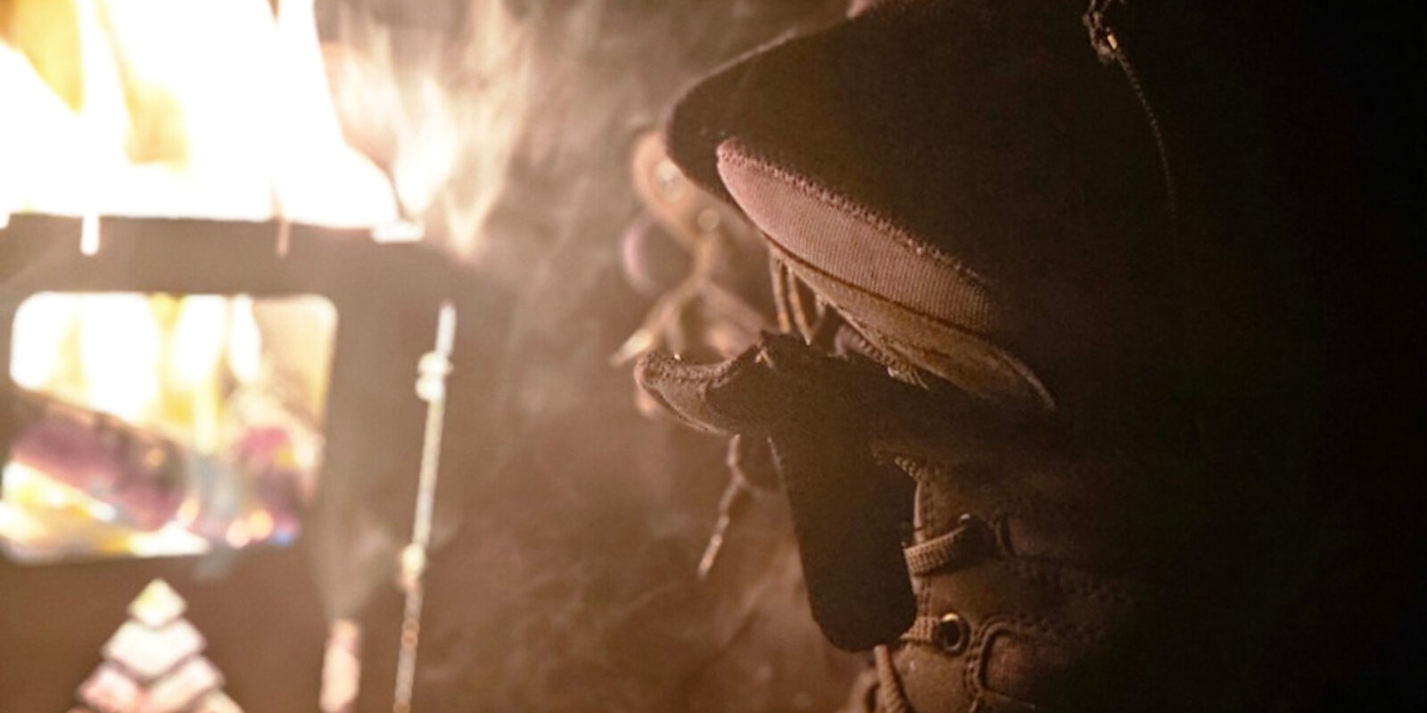 Boots warming beside a campfire at night